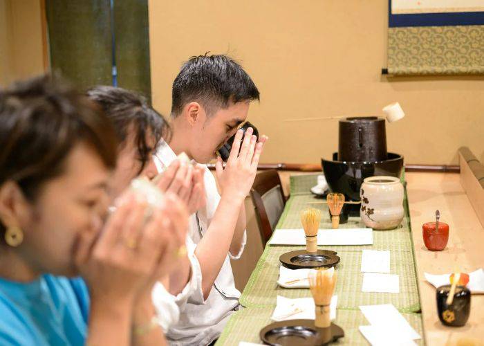 Guests at a matcha making experiences all drinking from their matcha cups.